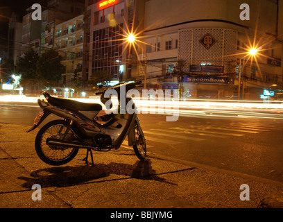 Une moto sur le trottoir dans une scène de nuit à Ho Chi Minh City Vietnam Banque D'Images