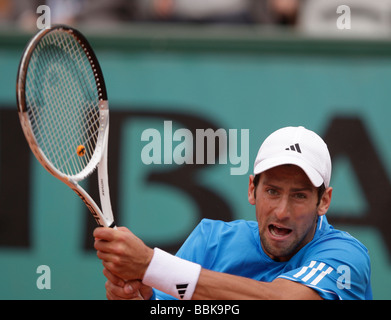 Joueur de tennis Novak Djokovic joue un retour de revers à Roland Garros Banque D'Images