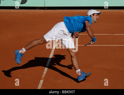 Joueur de tennis Novak Djokovic joue un service à Roland Garros Banque D'Images