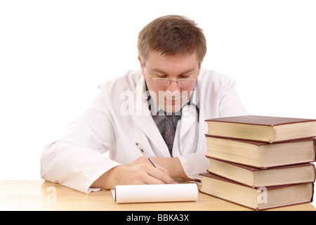 Jeune homme médecin l'étude de livres médicaux et la prise de notes - tourné sur fond blanc Banque D'Images