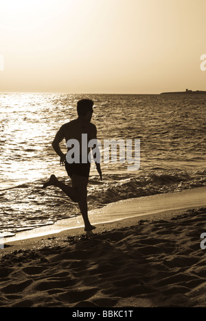 Man running on beach in San Giovanni Italie Sardaigne Banque D'Images