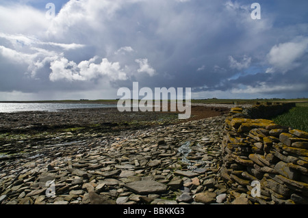 Les épouses de dh NORD Ithy RONALDSAY ORKNEY du Sud mur de pierre Taing plage rocheuse nuages de tempête Banque D'Images