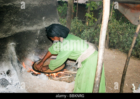 Afrique Ethiopie Lalibela Woman cooking Injera pancake comme du pain sur un mogogo sur un feu Banque D'Images