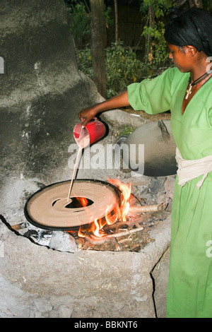 Afrique Ethiopie Lalibela Woman cooking Injera pancake comme du pain sur un mogogo sur un feu Banque D'Images