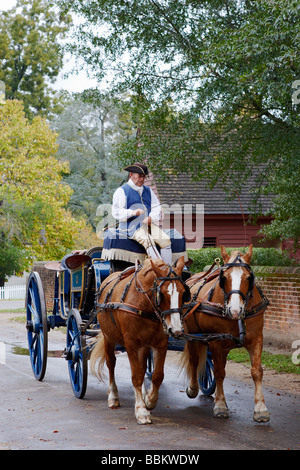 Un historique en costume d'interprète entraîne une calèche dans la ville coloniale de Williamsburg en Virginie Banque D'Images