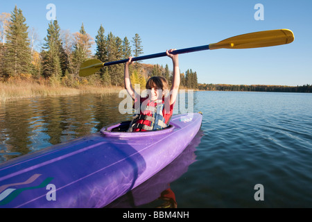 Smiling 10 year old boy holding paddle kayak ci-dessus, le lac Katherine, Parc national du Mont-Riding, Manitoba Banque D'Images