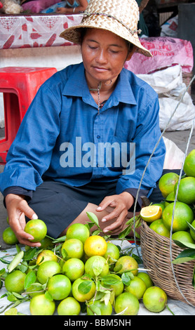 Femme vendant des limes dans un marché à Battambang, Cambodge Banque D'Images