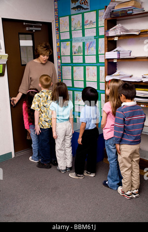 Les enfants jusqu'à la ligne de la classe porte chambre multi inter ethniques raciales diversifiées la diversité raciale multi culturel multiculturel maternelle interracial Banque D'Images