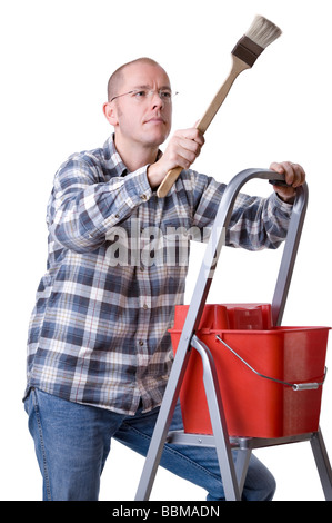 Studio photo de plein isolé un jeune artisan sur une échelle à l'aide d'un pinceau Banque D'Images