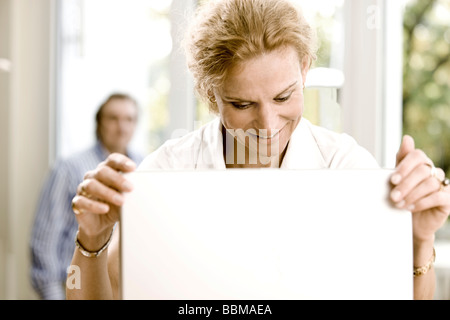 Femme au travail sur un ordinateur portable, l'homme à l'arrière Banque D'Images