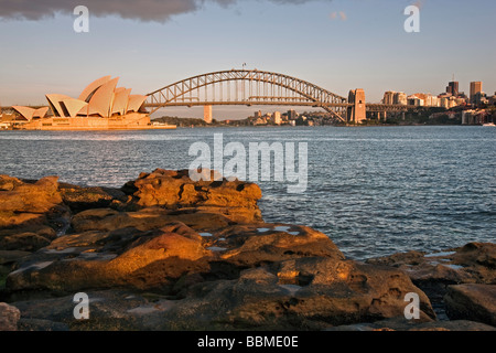 Australie Nouvelle Galles du Sud. Opéra de Sydney et le Harbour Bridge au lever du soleil. Banque D'Images