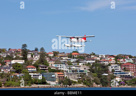 Australie Nouvelle Galles du Sud. Une lumière avec des flotteurs amphibiens volant à basse altitude au-dessus du port de Sydney. Banque D'Images