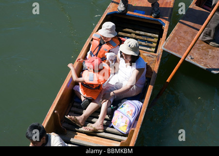 Une jeune famille en barque sur la rivière Cam, Cambridge, Royaume-Uni sous le soleil d'été Banque D'Images