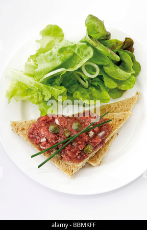 En Tartare sur toast avec des câpres, oignons et salade Banque D'Images