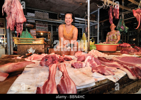 Femme au marché un décrochage avec différentes sortes de viande, suspendu à crochets en métal, de la viande, du marché, de Vinh Long Delta du Mékong, Vietnam, Banque D'Images