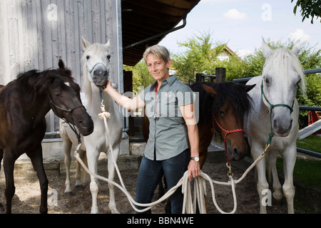 Vétérinaire spécialisé dans les animaux de grande taille avec ses quatre chevaux, Steinmaur, Zurich, Switzerland, Europe Banque D'Images