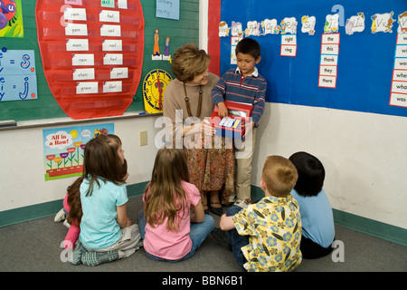 Les enfants du groupe scolaire élémentaire séance tapis chambre classe raciale ethnique interracial multiculturel retour voir les élèves de maternelle © Myrleen chefs M. Pearson Banque D'Images