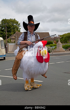 L'homme habillé en cowboy avec des armes d'équitation grande Foire de rue poulet UK Cleeve Évêques Banque D'Images