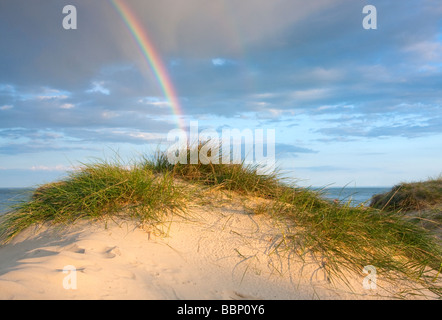 Arc-en-ciel dramatique dans la chaude lumière du soir sur Walberswick dunes de sable sur la côte du Suffolk Banque D'Images