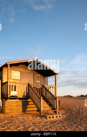 Cabines de plage à Walberswick illuminée par la lumière d'été chaude soirée sur la côte du Suffolk. Banque D'Images