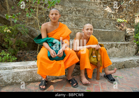 Deux moines bouddhistes débutants s'asseoir sur les marches sur le chemin d'Phou Si Hill à Luang Prabang au Laos Banque D'Images