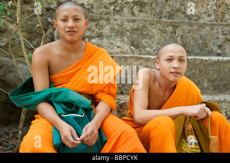 Close up de deux bonzes novices s'asseoir sur les marches sur le chemin d'Phou Si Hill à Luang Prabang au Laos Banque D'Images