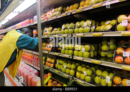 Ouvrier stockant des étagères dans un supermarché, la capitale de Lilongwe, Malawi Afrique Banque D'Images