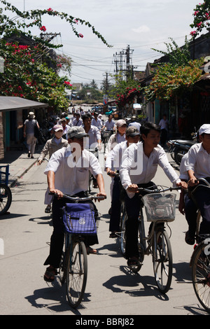 [École des garçons] faire du vélo sur route passagère, 'Hoi An, Vietnam' Banque D'Images