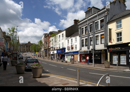 Boutiques dans la rue principale du centre-ville d'Omagh menant au palais sur la colline du comté de Tyrone en Irlande du Nord uk Banque D'Images