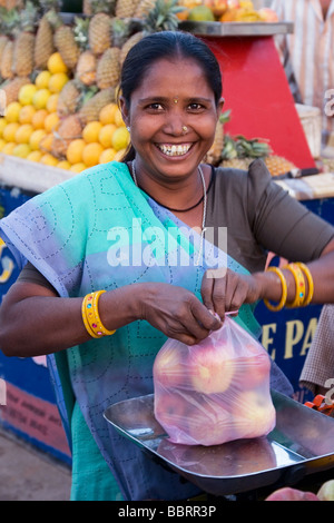 Femme Fruit-Seller Fruits Liens indien dans un sac de plastique. Bhuj, Kutch Région, État du Gujarat, Inde Banque D'Images