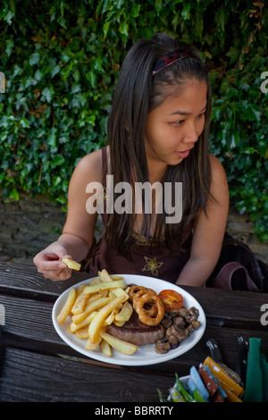 Tourisme Oriental dame trys son premier Western steak-frites meal Banque D'Images