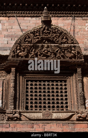 Katmandou, Népal. La sculpture sur bois au-dessus d'une fenêtre dans la Kumari Bahal, Maison de la Kumari Devi, une jeune fille vénérée par les Hindous comme une déesse vivante. Banque D'Images