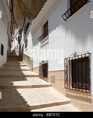 Une vieille dame nettoie les rues étroites de Setenil de las Bodegas dans la province de Cadix, Andalousie, espagne. Banque D'Images