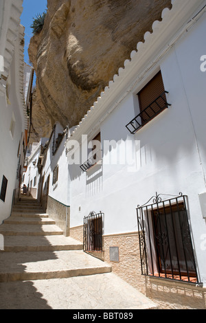 Une vieille dame nettoie les rues étroites de Setenil de las Bodegas dans la province de Cadix, Andalousie, espagne. Banque D'Images