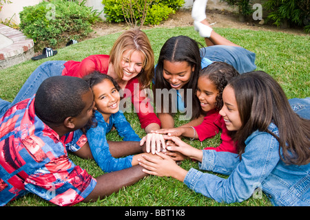 Grande famille d'origine africaine ou Caucasian family playing ethniques contact visuel à la diversité raciale bi caméra divers biracial interracial MR © Myrleen Pearson Banque D'Images