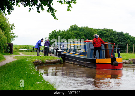 L'équipage d'une péniche négocier une des portes à Tyrley écluses sur le canal de Shropshire Union Banque D'Images