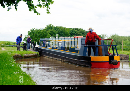 L'équipage d'une péniche négocier une des portes à Tyrley écluses sur le canal de Shropshire Union Banque D'Images