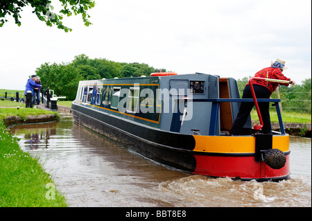 L'équipage d'une péniche négocier une des portes à Tyrley écluses sur le canal de Shropshire Union Banque D'Images