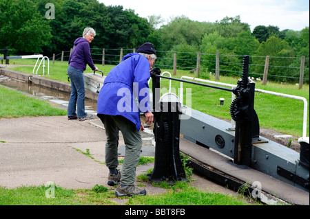 L'équipage d'une péniche négocier une des portes à Tyrley écluses sur le canal de Shropshire Union Banque D'Images