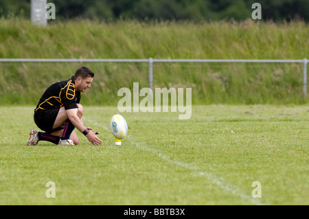 Joueur de rugby ball lieux soigneusement avant de tenter une conversion Banque D'Images