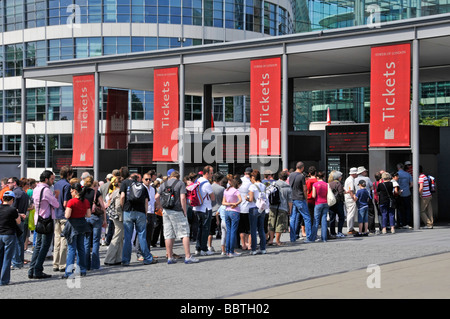 Bannières rouges devant les guichets de la Tour de Londres touristes visiteurs attendant dans une longue file d'attente pour visiter le célèbre monument historique Tower Hill Angleterre Banque D'Images