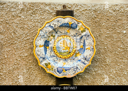 Une plaque en céramique cannelée sur le mur extérieur d'un magasin de poterie dans la ville ombrienne de Deruta Banque D'Images