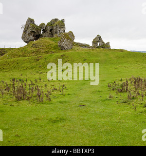 Ruines du château de Clonmacnoise vache avec le pâturage. Quelques fragments tordus de la maçonnerie en pierre au sommet d'un monticule situé dans un pâturage Banque D'Images