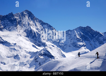 Skieurs sur piste de neige à Zinal avec pistes en retour, Weisshorn Valais, Suisse Banque D'Images