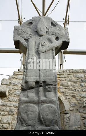 Doorty Cross face est : Saint Pierre. C'est high cross visage montre St Peter bénédiction deux membres du clergé irlandais Banque D'Images
