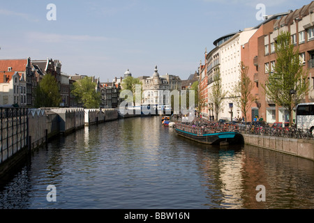 Le canal Singel à Amsterdam avec le marché aux fleurs flottant sur la gauche Banque D'Images