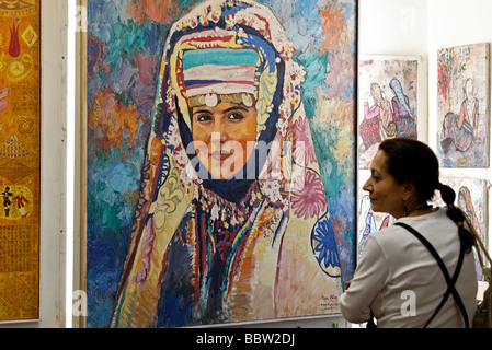 Femme regardant une peinture d'une femme en costume traditionnel anatolien, galerie d'art, Sultanahmet, Istanbul, Turquie Banque D'Images