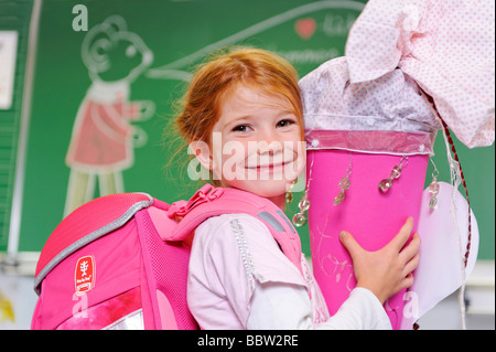 Jeune fille à sa première journée à l'école tenant une schultuete, cône école rempli de bonbons et de cadeaux Banque D'Images