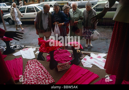 Les retraités se réunissent à l'extérieur d'un magasin de vêtements de mode pour femmes dans la rue principale de Frinton and distinguée-sur-Mer Banque D'Images