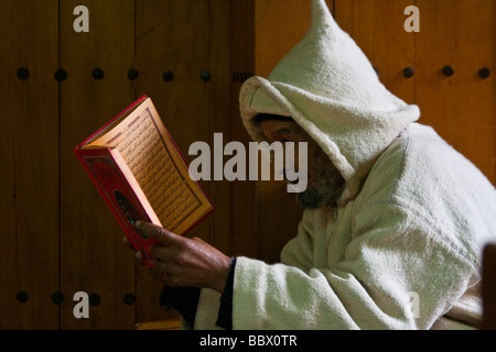 Homme marocain de lire un livre en arabe dans la vieille ville de Fès Maroc Banque D'Images